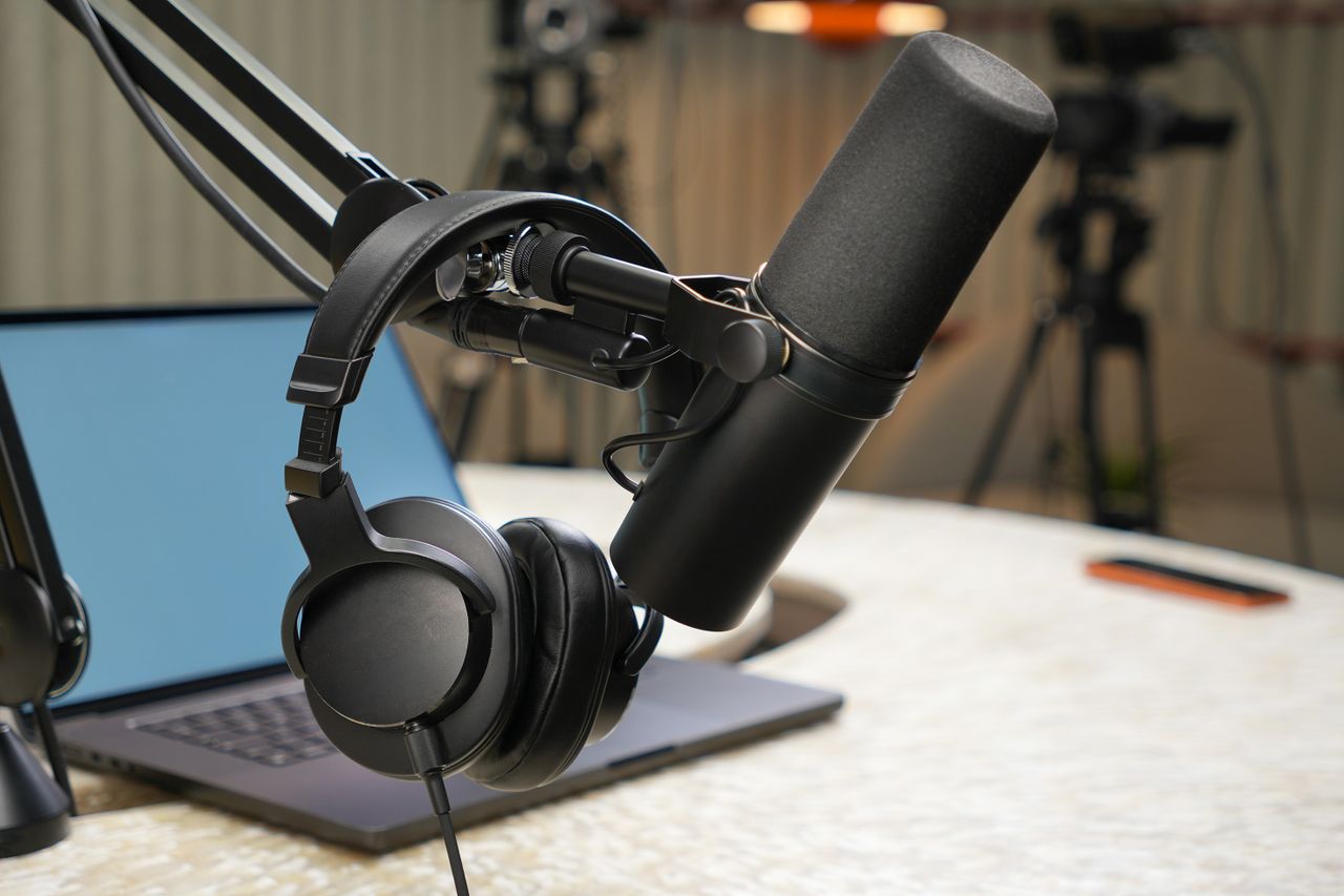 Close-up of a podcast studio setup featuring a microphone and headphones.